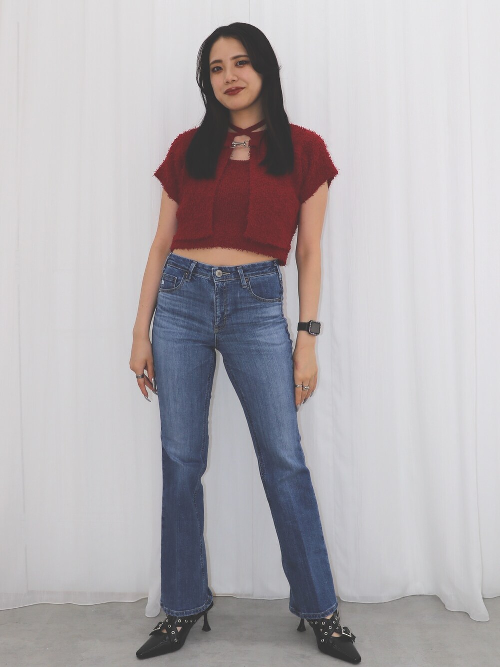 ブルー系のデニムパンツ、レッド系のアンサンブル、ブラック系のパンプスを着用したレディースの夏コーディネートの2枚目の写真