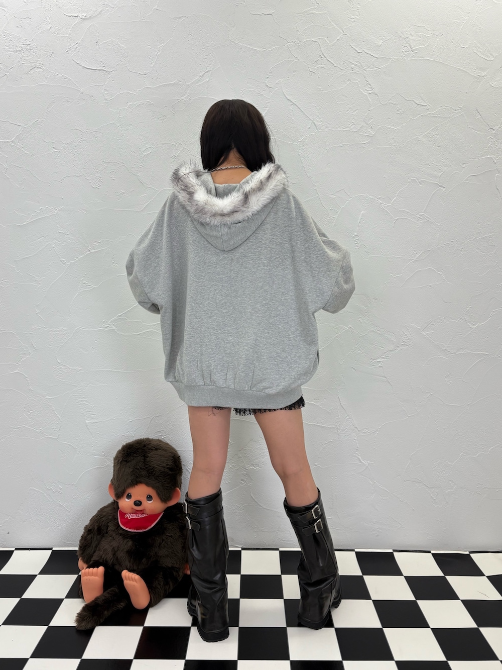 グレー系のパーカー、ブラック系のブーツ、ピンク系のショルダーバッグを着用したレディースの夏コーディネートの4枚目の写真