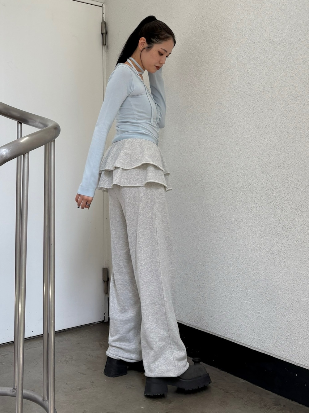 ブルー系のニット/セーター、グレー系のスウェットパンツを着用したレディースの夏コーディネートの2枚目の写真