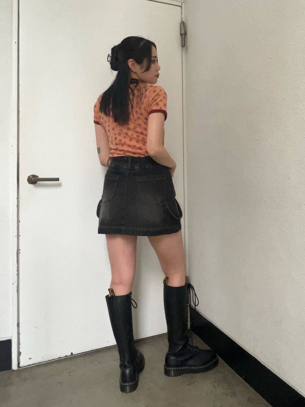 オレンジ系のTシャツ/カットソー、ブラック系のスカートを着用したレディースの夏コーディネートの2枚目の写真