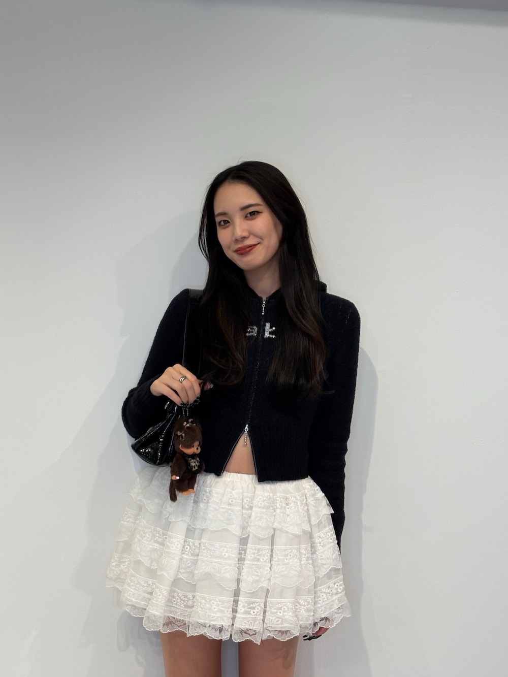 ブラック系のパーカー、ブラック系のハンドバッグ、ホワイト系のその他パンツを着用したレディースの秋コーディネートの3枚目の写真