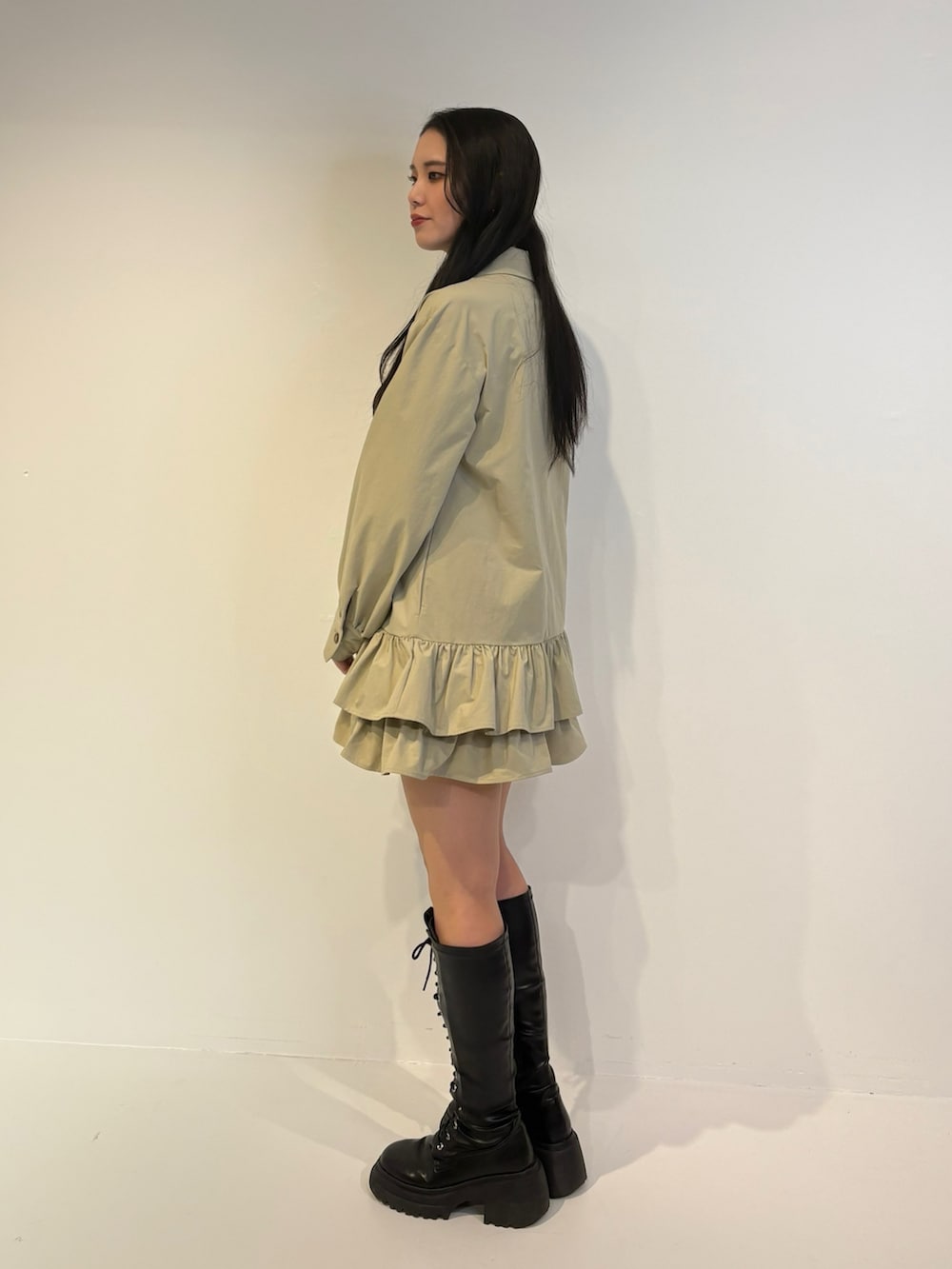 ベージュ系のワンピース、ブラック系のブーツを着用したレディースの秋コーディネートの2枚目の写真