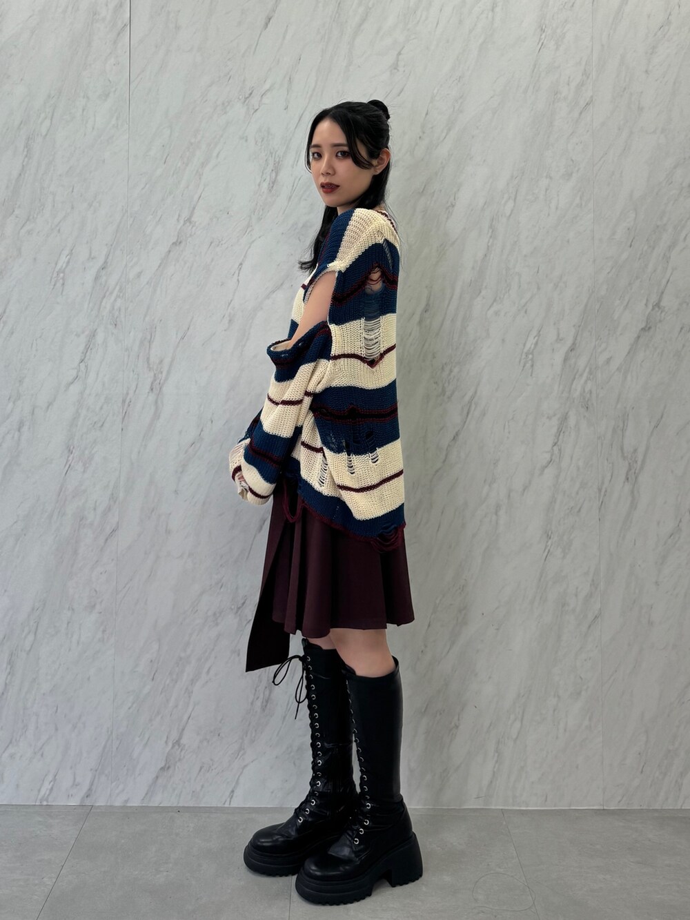 ホワイト系のニット/セーター、レッド系のスカート、ブラック系のブーツを着用したレディースの春コーディネートの3枚目の写真