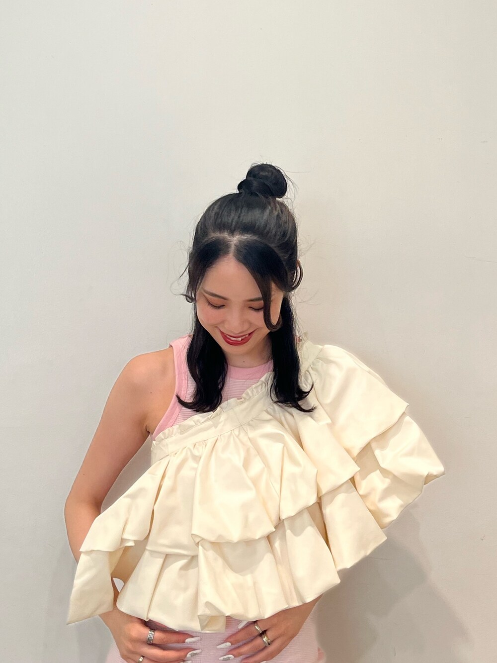 ピンク系のワンピース、ホワイト系のスカート、ブラウン系のブーツを着用したレディースの春コーディネートの3枚目の写真