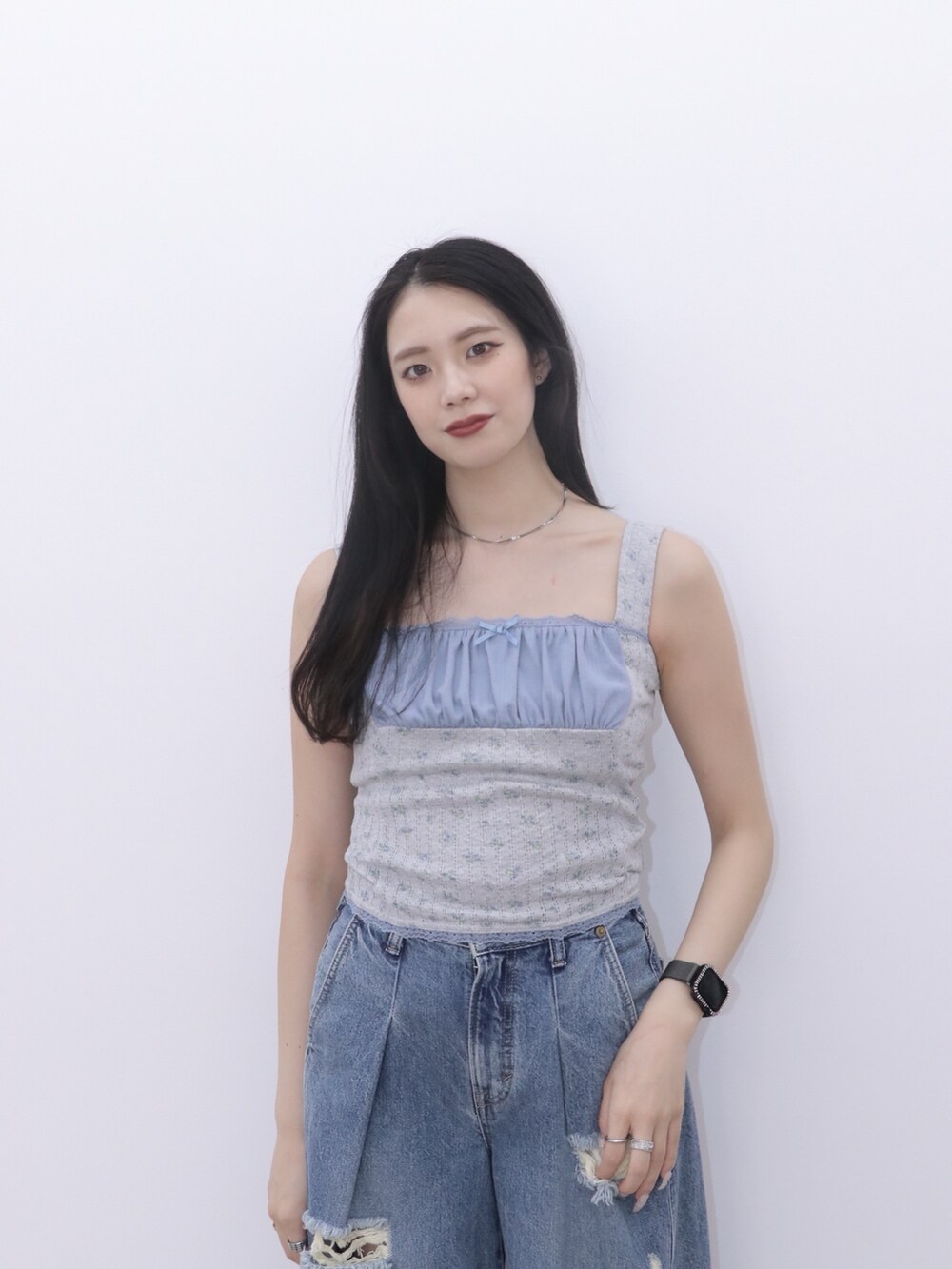 ブルー系のデニムパンツ、グレー系のキャミソール、ブラック系のパンプスを着用したレディースの冬コーディネートの5枚目の写真