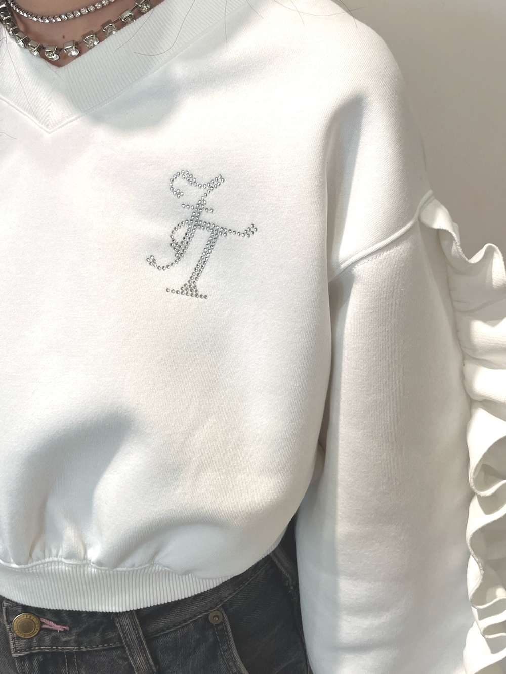 ブラック系のデニムパンツ、ブラック系のパンプス、ホワイト系のスウェットを着用したレディースの冬コーディネートの4枚目の写真