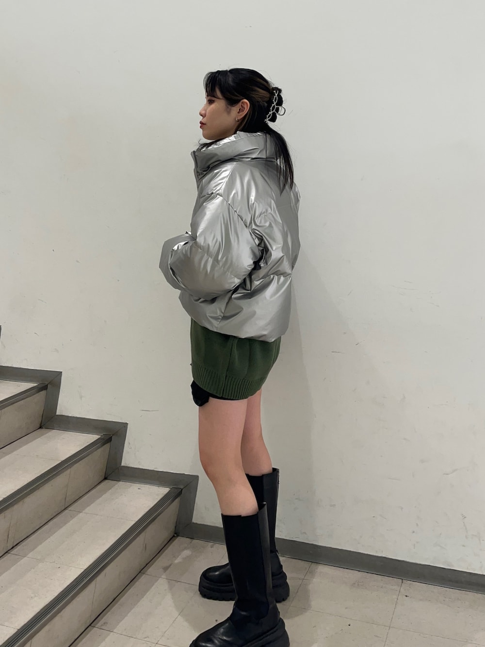 シルバー系のダウンジャケット/コート、グリーン系のニット/セーター、ブラック系のその他パンツを着用したレディースの冬コーディネートの2枚目の写真