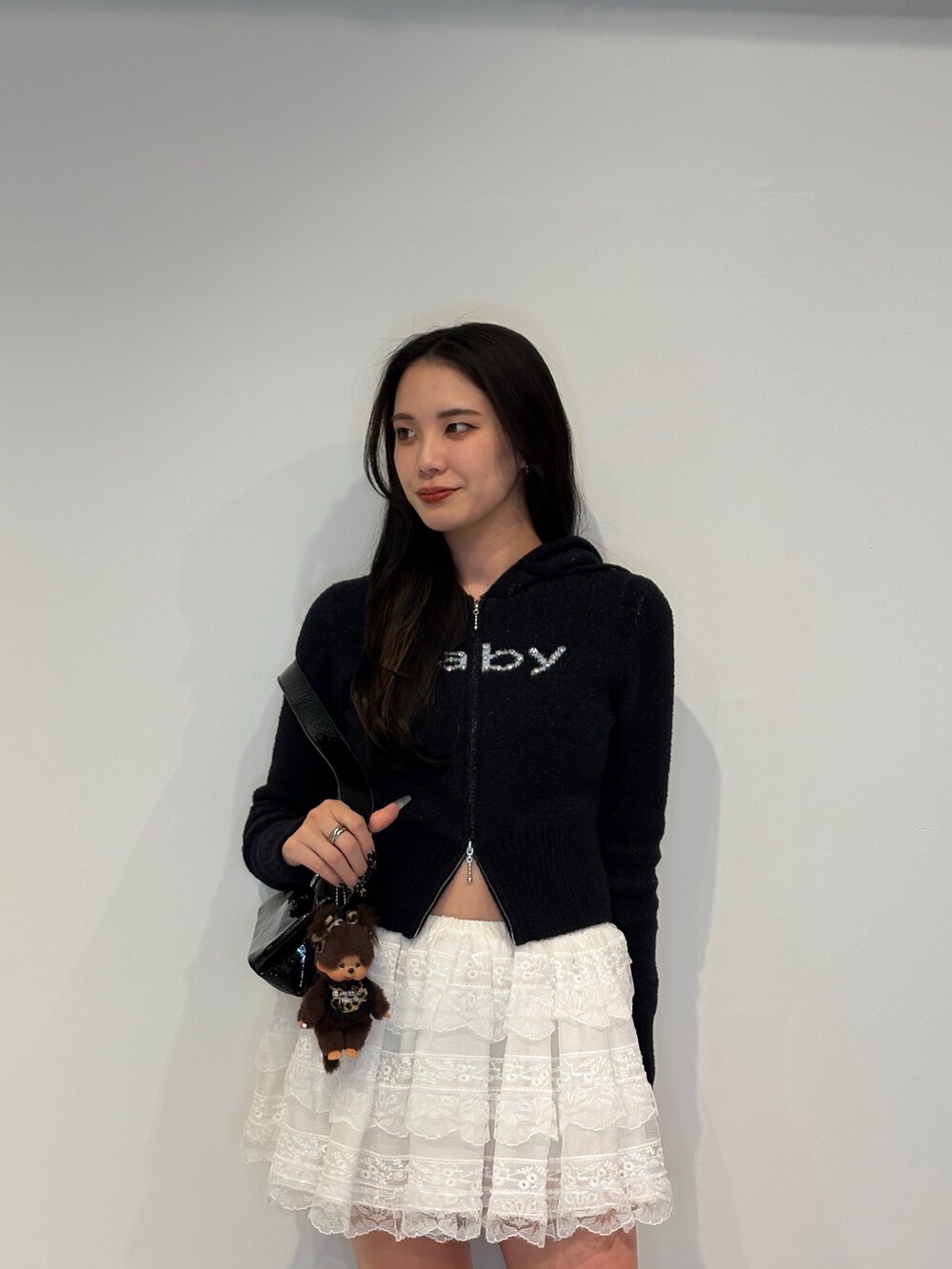 ブラック系のパーカー、ブラック系のハンドバッグ、ホワイト系のその他パンツを着用したレディースの秋コーディネートの4枚目の写真