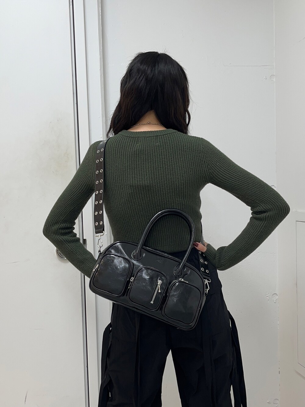 グリーン系のニット/セーター、ブラック系のその他パンツ、ブラック系のボストンバッグを着用したレディースの冬コーディネートの4枚目の写真