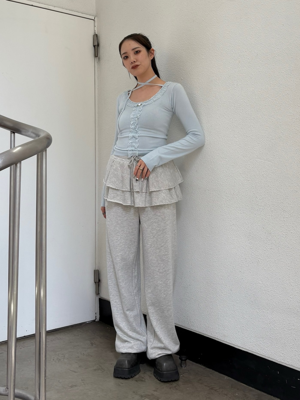 ブルー系のニット/セーター、グレー系のスウェットパンツを着用したレディースの夏コーディネートの3枚目の写真