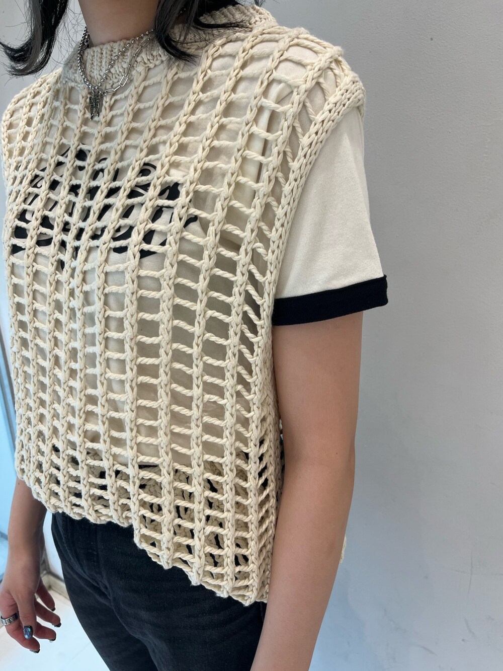 ブラック系のデニムパンツ、ホワイト系のTシャツ/カットソー、ホワイト系のベストを着用したレディースの春コーディネートの7枚目の写真