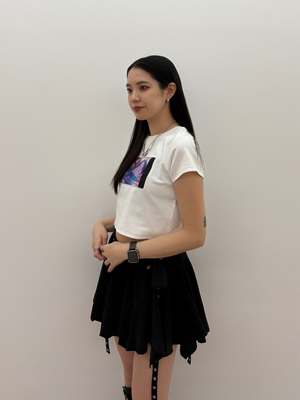 ブラック系のスカート、ホワイト系のTシャツ/カットソーを着用したレディースの春コーディネートの3枚目の写真