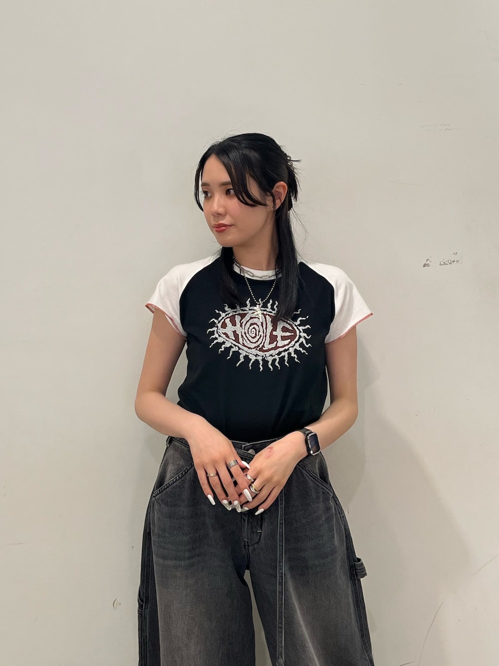 ブラック系のTシャツ/カットソー、ブラック系のデニムパンツを着用したレディースの春コーディネートの5枚目の写真