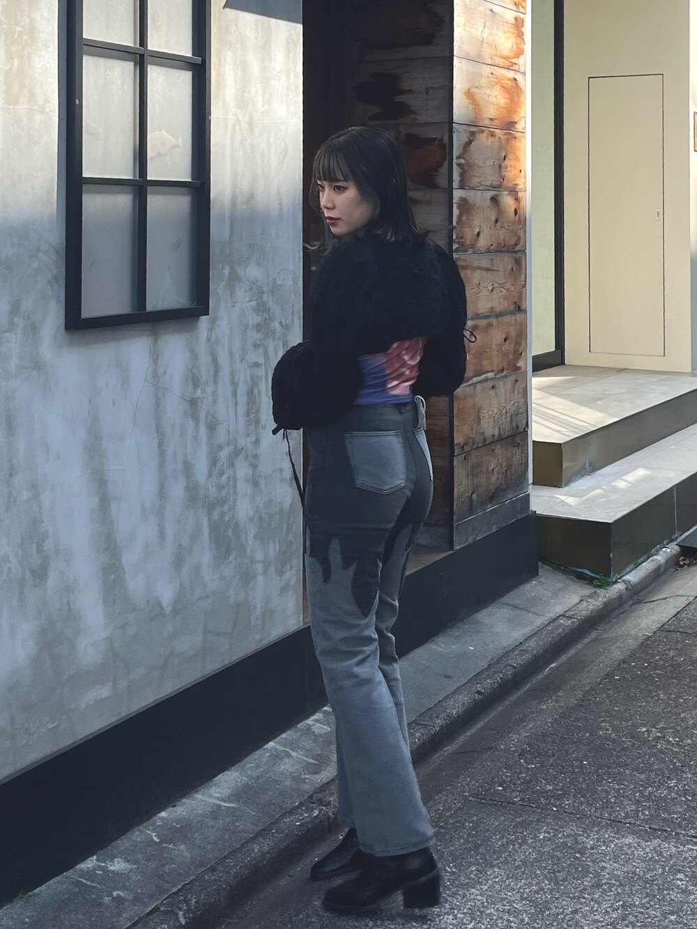 ブラック系のデニムパンツ、ブラック系のカーディガン/ボレロ、パープル系のTシャツ/カットソーを着用したレディースの春コーディネートの2枚目の写真