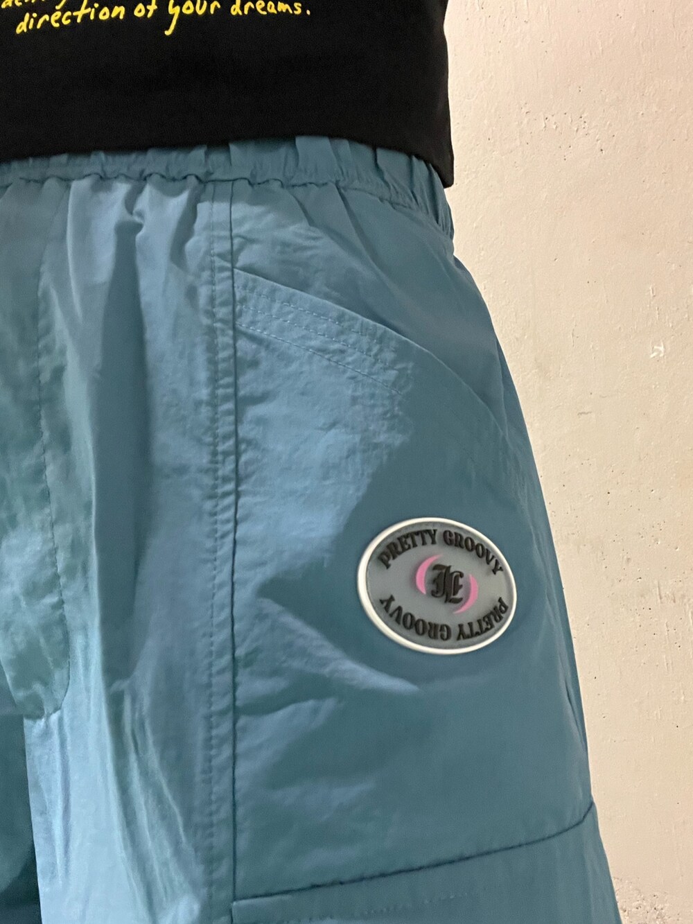 ブルー系のカーゴパンツ、ブラック系のサンダル、ブラック系のTシャツ/カットソーを着用したレディースの夏コーディネートの6枚目の写真