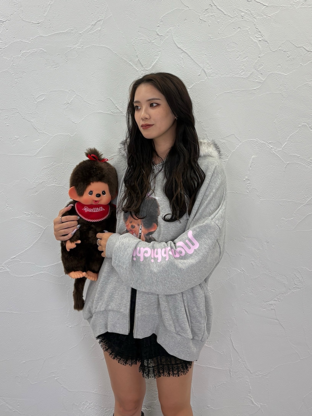 グレー系のパーカー、ブラック系のブーツ、ピンク系のショルダーバッグを着用したレディースの夏コーディネートの3枚目の写真