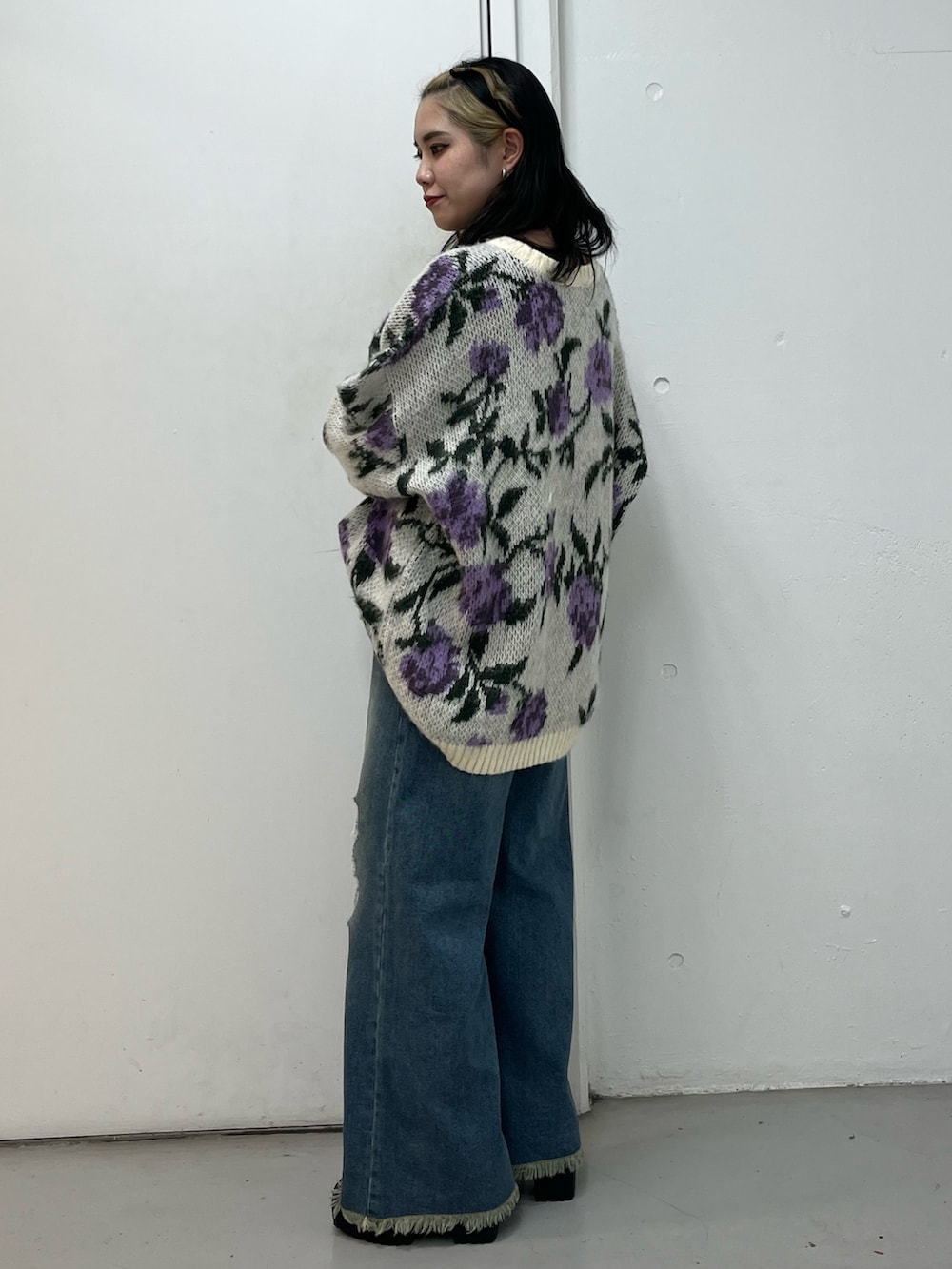 ブルー系のデニムパンツ、ブラック系のブーツ、ホワイト系のニット/セーターを着用したレディースの冬コーディネートの3枚目の写真