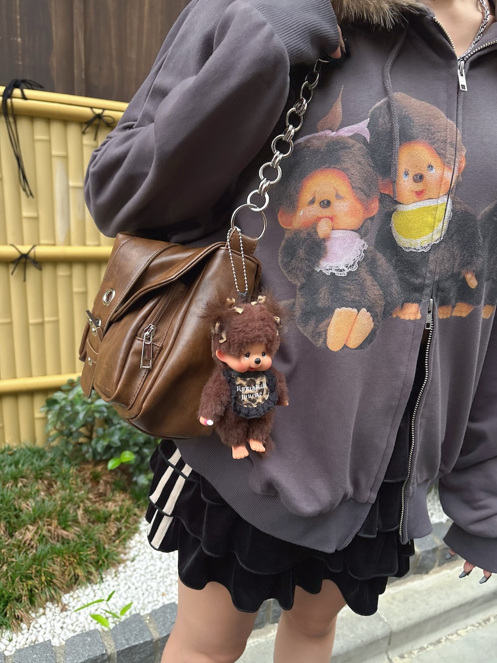 ブラック系のパーカー、ブラック系のスカート、ブラウン系のキーホルダーを着用したレディースの秋コーディネートの4枚目の写真