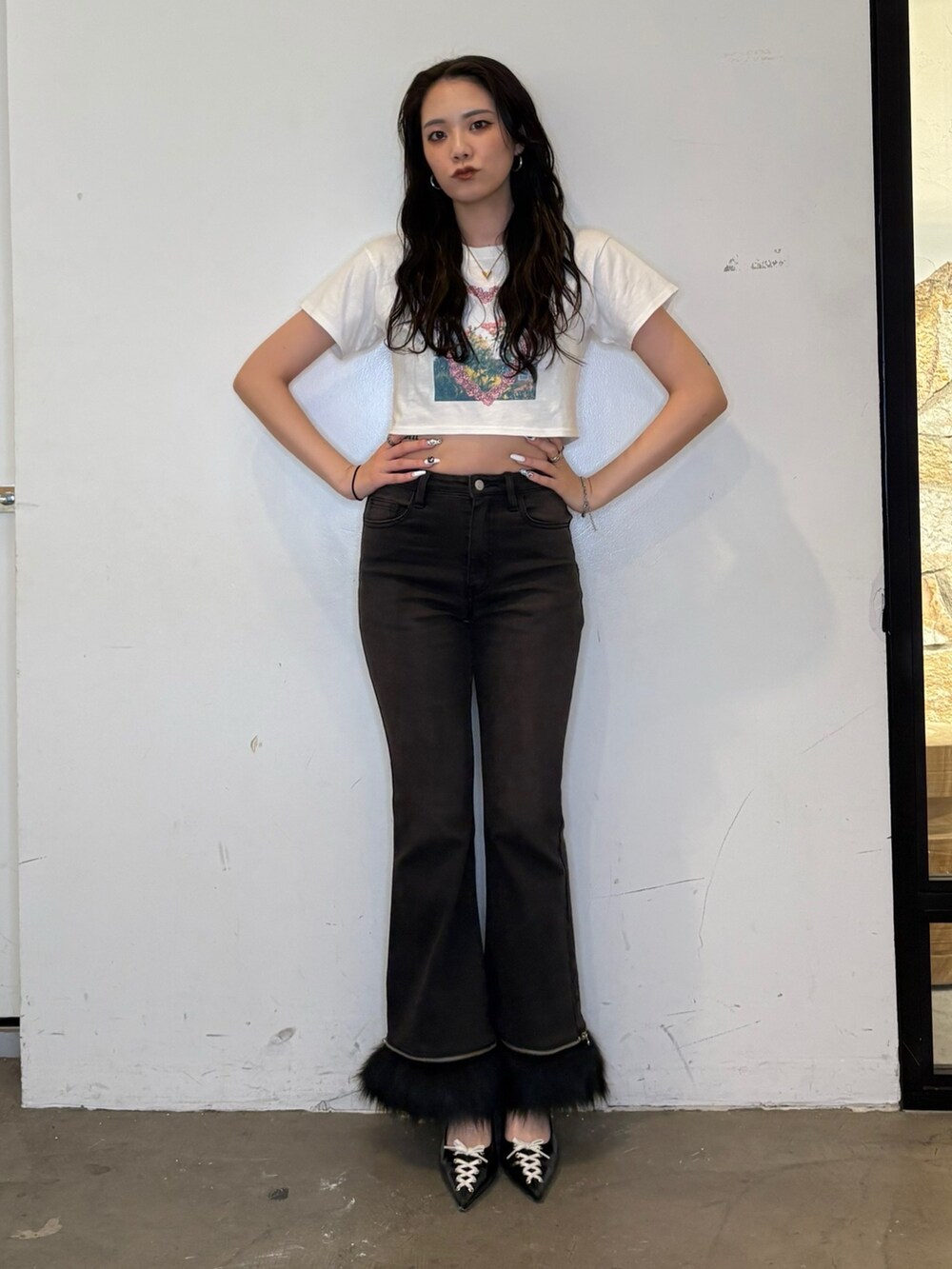 ホワイト系のTシャツ/カットソー、ブラック系のデニムパンツ、ブラック系のパンプスを着用したレディースの夏コーディネートの2枚目の写真