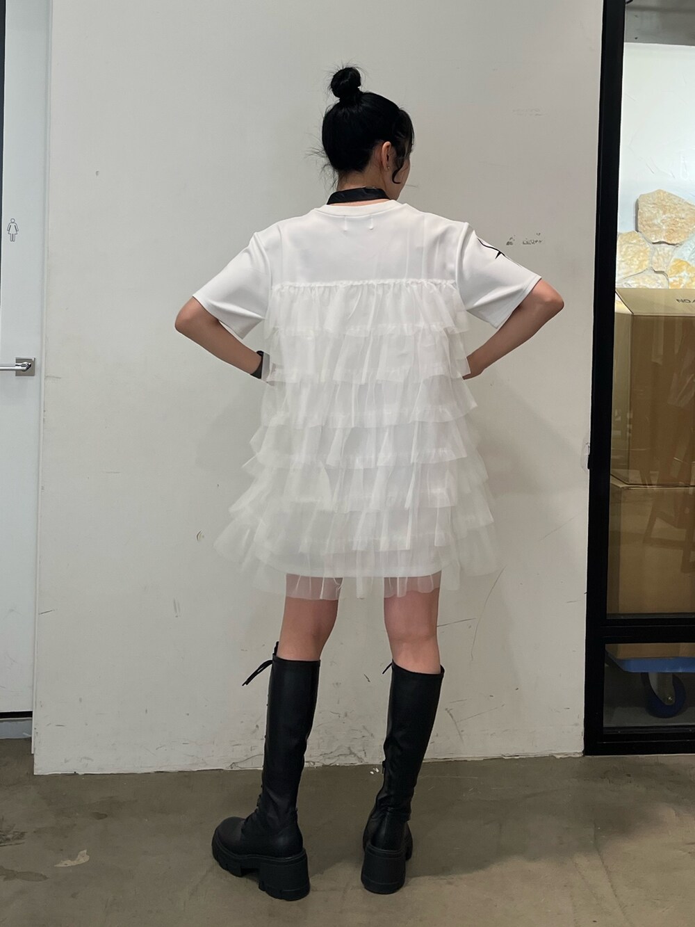 ホワイト系のワンピース、ブラック系のブーツを着用したレディースの春コーディネートの3枚目の写真