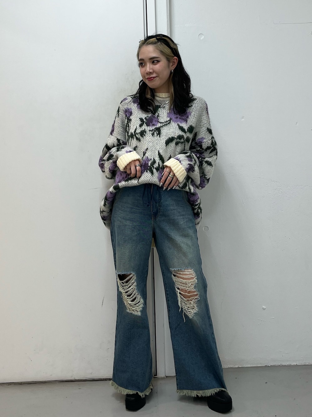 ブルー系のデニムパンツ、ブラック系のブーツ、ホワイト系のニット/セーターを着用したレディースの冬コーディネートの2枚目の写真