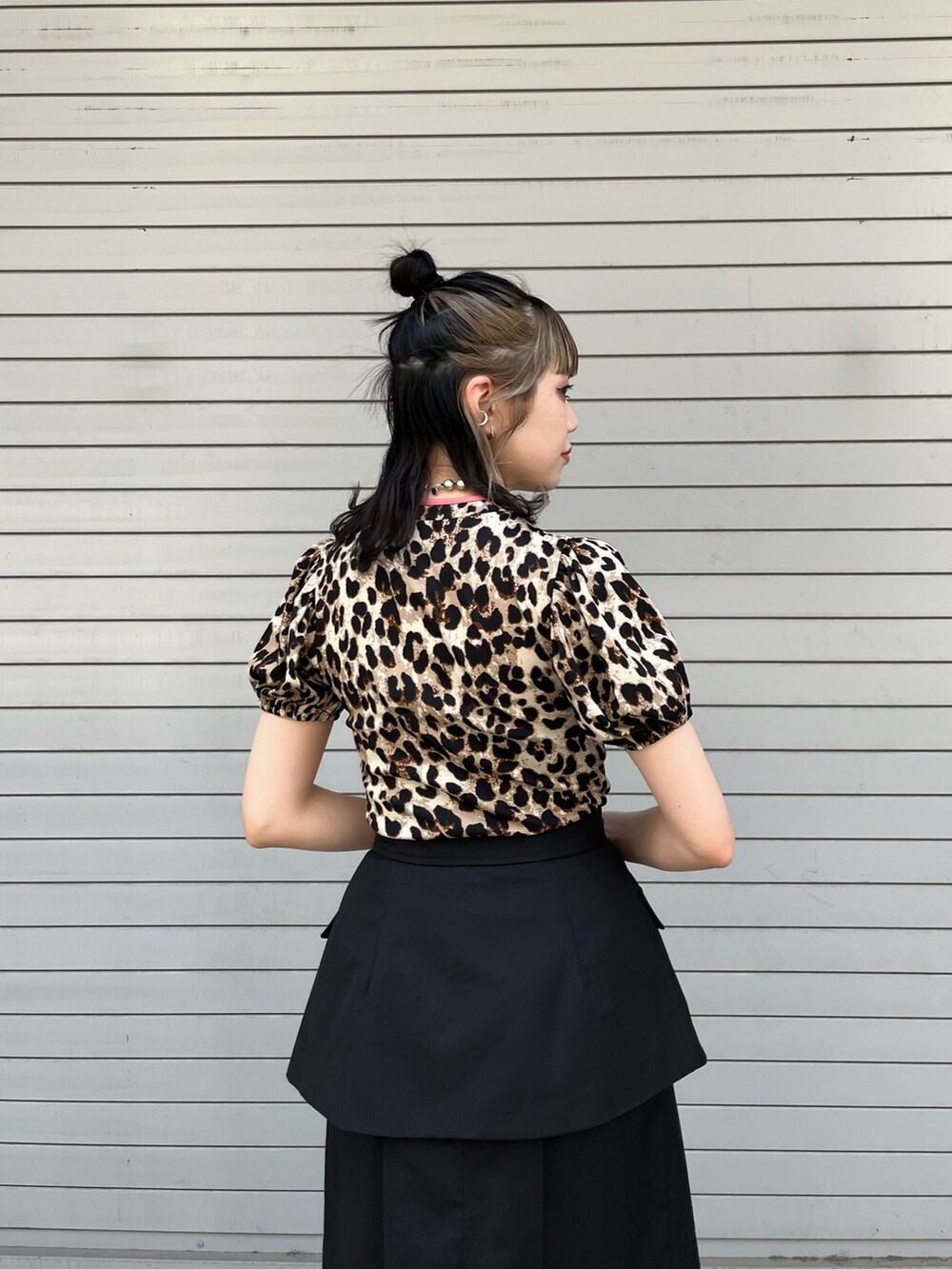 ブラック系のスカート、ブラック系のハンドバッグ、ベージュ系のTシャツ/カットソーを着用したレディースの春コーディネートの5枚目の写真