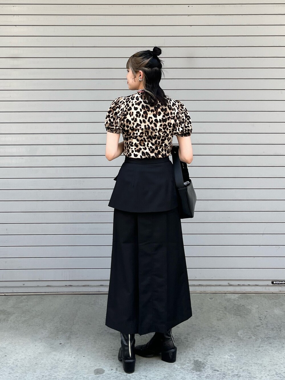 ブラック系のスカート、ブラック系のハンドバッグ、ベージュ系のTシャツ/カットソーを着用したレディースの春コーディネートの3枚目の写真