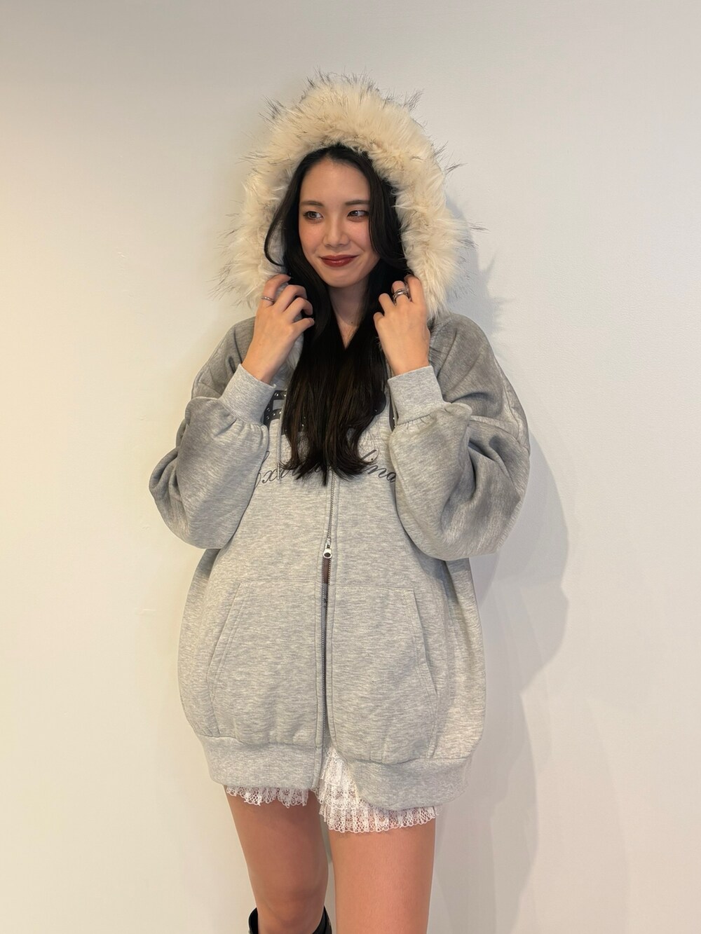 グレー系のパーカー、ブラック系のブーツを着用したレディースの秋コーディネートの5枚目の写真