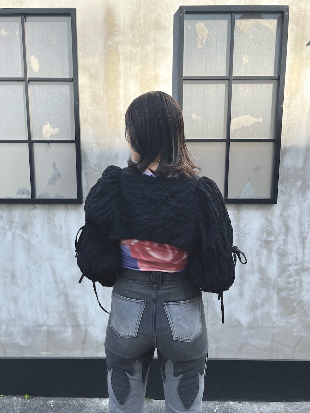 ブラック系のデニムパンツ、ブラック系のカーディガン/ボレロ、パープル系のTシャツ/カットソーを着用したレディースの春コーディネートの5枚目の写真