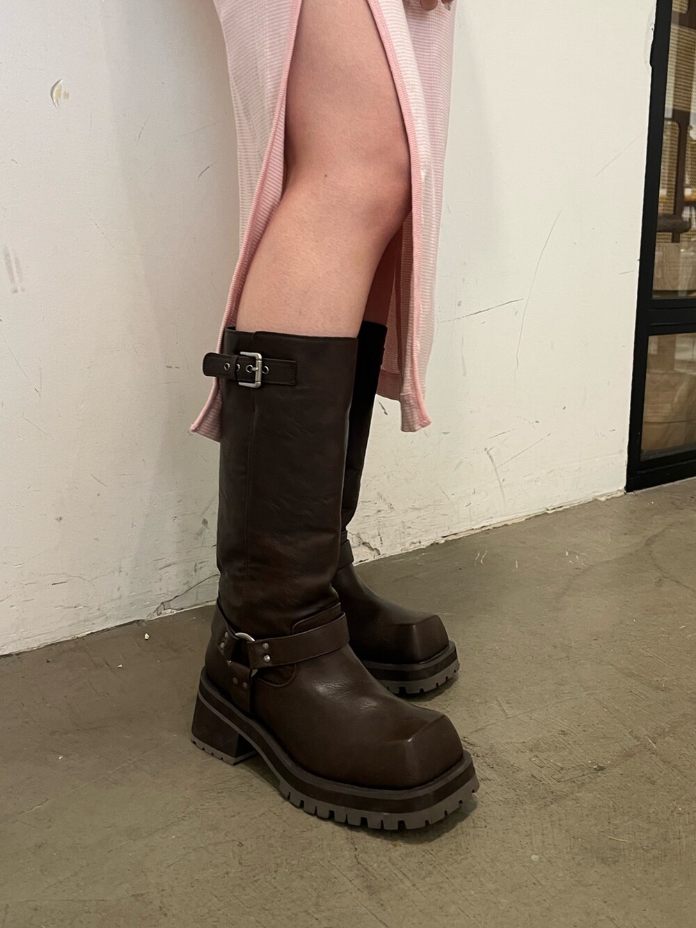 ピンク系のワンピース、ホワイト系のスカート、ブラウン系のブーツを着用したレディースの春コーディネートの7枚目の写真