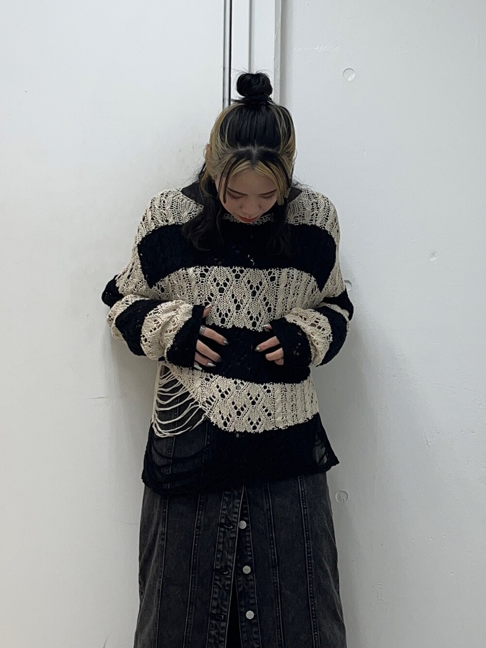 ブラック系のニット/セーター、ブラック系のワンピース、ブラック系のブーツを着用したレディースの冬コーディネートの5枚目の写真