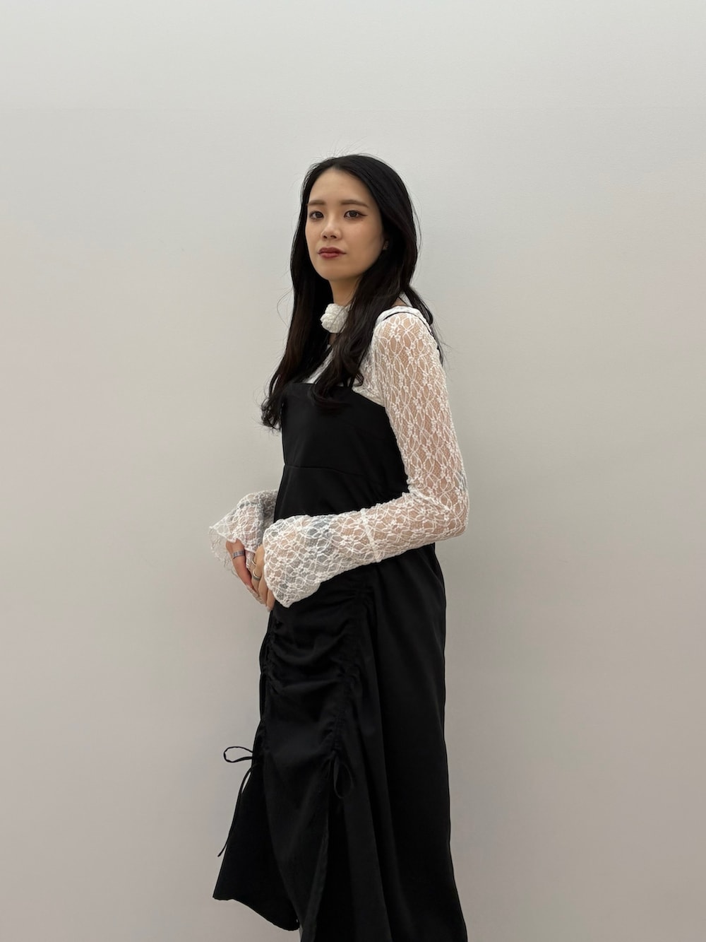 ブラック系のワンピース、ホワイト系のTシャツ/カットソー、ブラック系のブーツを着用したレディースの春コーディネートの3枚目の写真