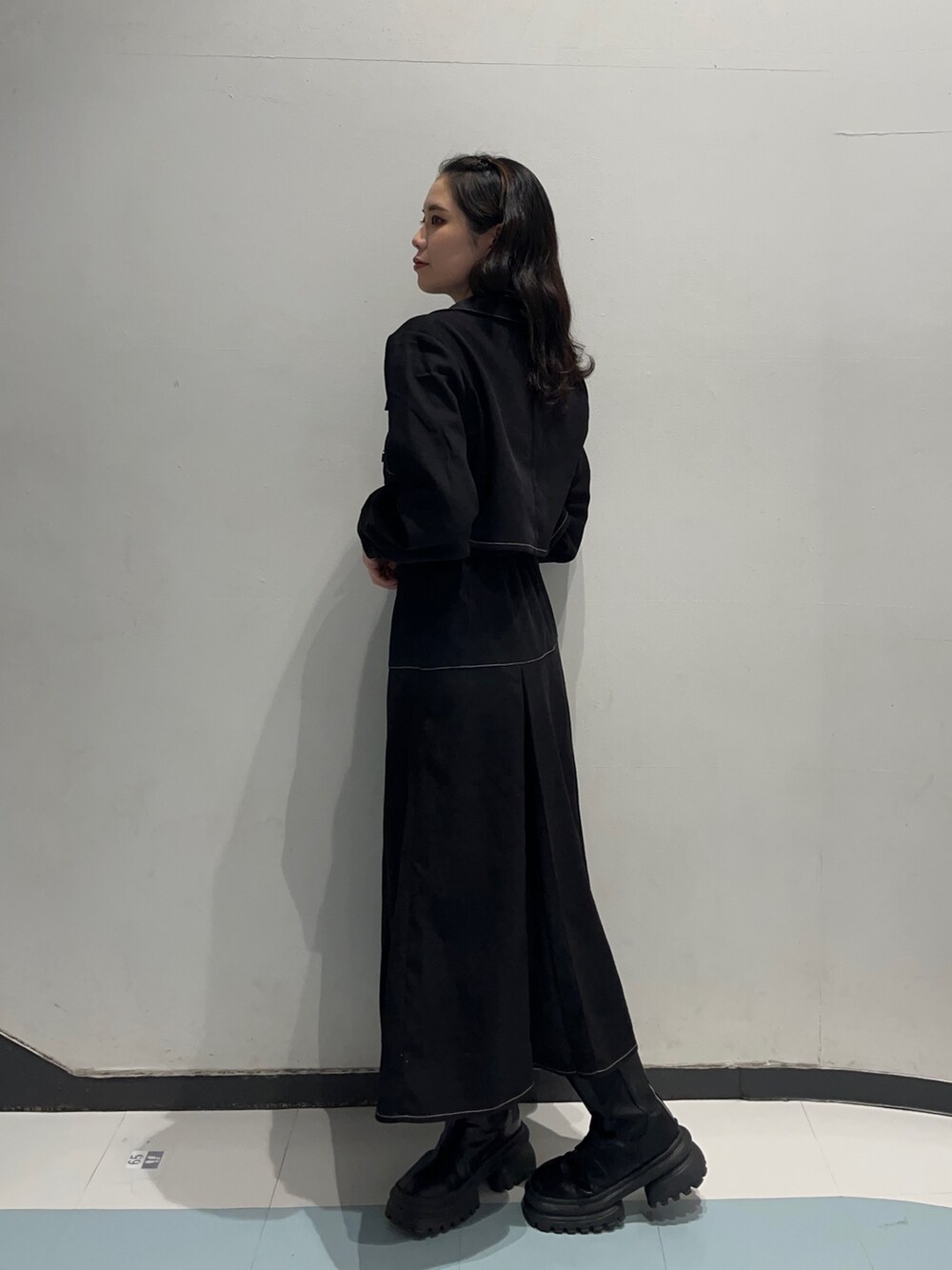 ブラック系のワンピース、ブラック系のブーツ、ブラック系のTシャツ/カットソーを着用したレディースの冬コーディネートの2枚目の写真