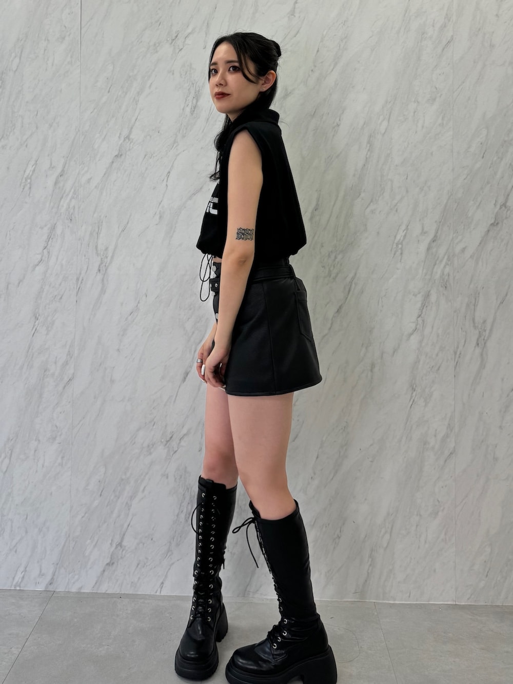 ブラック系のTシャツ/カットソー、ブラック系のスカート、ブラック系のブーツを着用したレディースの夏コーディネートの2枚目の写真