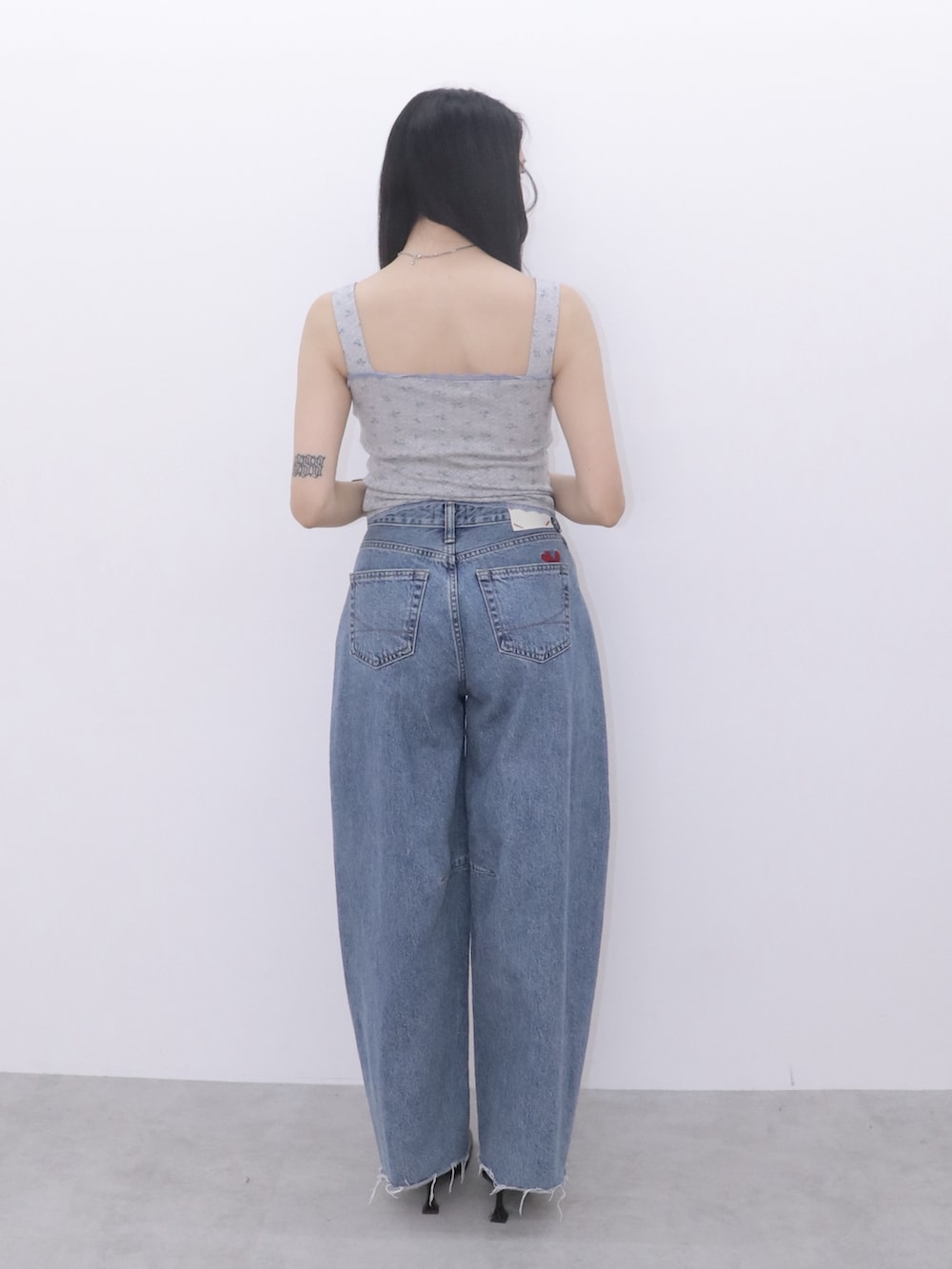 ブルー系のデニムパンツ、グレー系のキャミソール、ブラック系のパンプスを着用したレディースの冬コーディネートの3枚目の写真