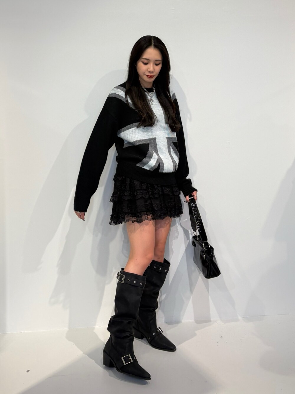 ブラック系のニット/セーター、ブラック系のその他パンツ、ブラック系のハンドバッグを着用したレディースの秋コーディネートの2枚目の写真