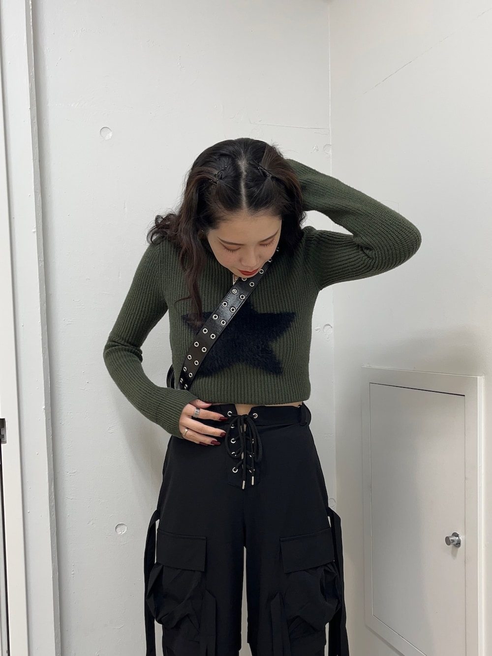 グリーン系のニット/セーター、ブラック系のその他パンツ、ブラック系のボストンバッグを着用したレディースの冬コーディネートの5枚目の写真