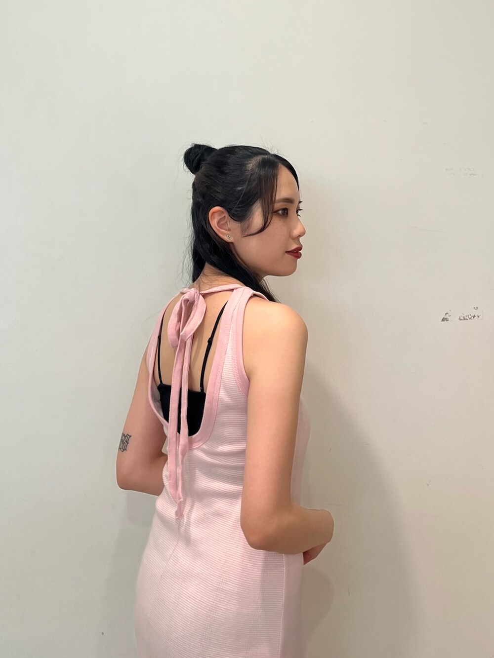 ピンク系のワンピース、ホワイト系のスカート、ブラウン系のブーツを着用したレディースの春コーディネートの6枚目の写真