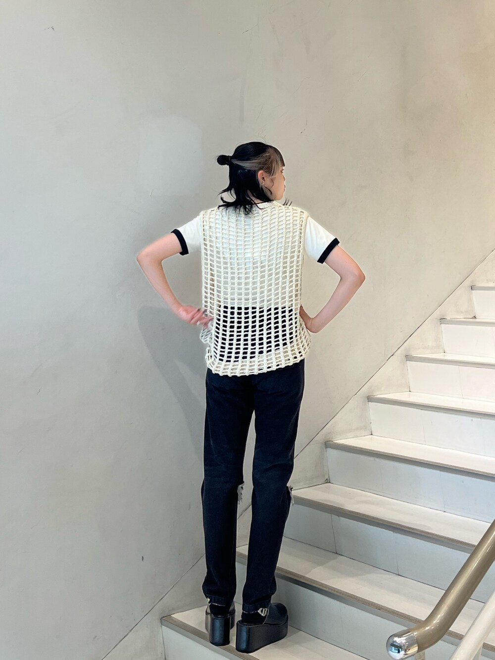 ブラック系のデニムパンツ、ホワイト系のTシャツ/カットソー、ホワイト系のベストを着用したレディースの春コーディネートの3枚目の写真