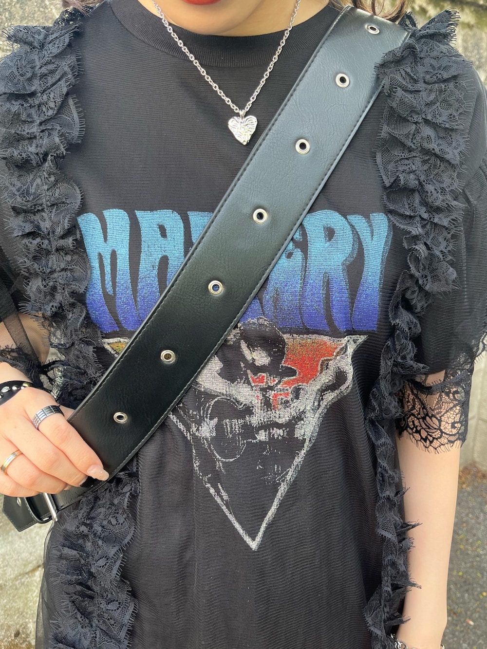 ブラック系のワンピース、ブラック系のメッセンジャーバッグ、ブラック系のブーツを着用したレディースの春コーディネートの7枚目の写真