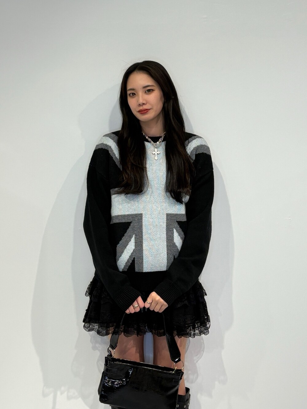 ブラック系のニット/セーター、ブラック系のその他パンツ、ブラック系のハンドバッグを着用したレディースの秋コーディネートの4枚目の写真