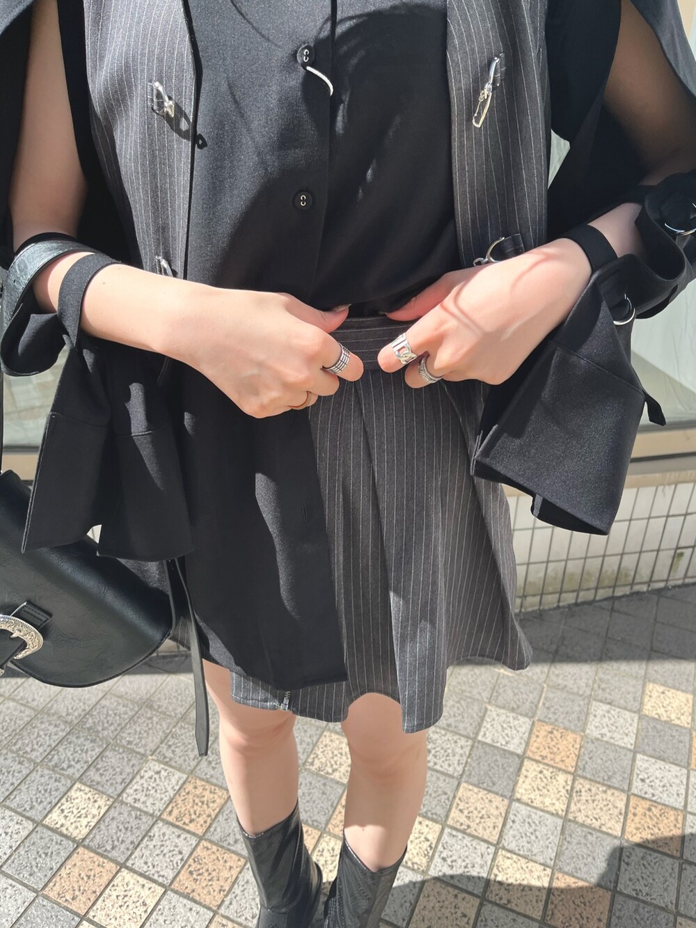 ブラック系のシャツ/ブラウス、グレー系のベスト、ブラック系のブーツを着用したレディースの春コーディネートの8枚目の写真