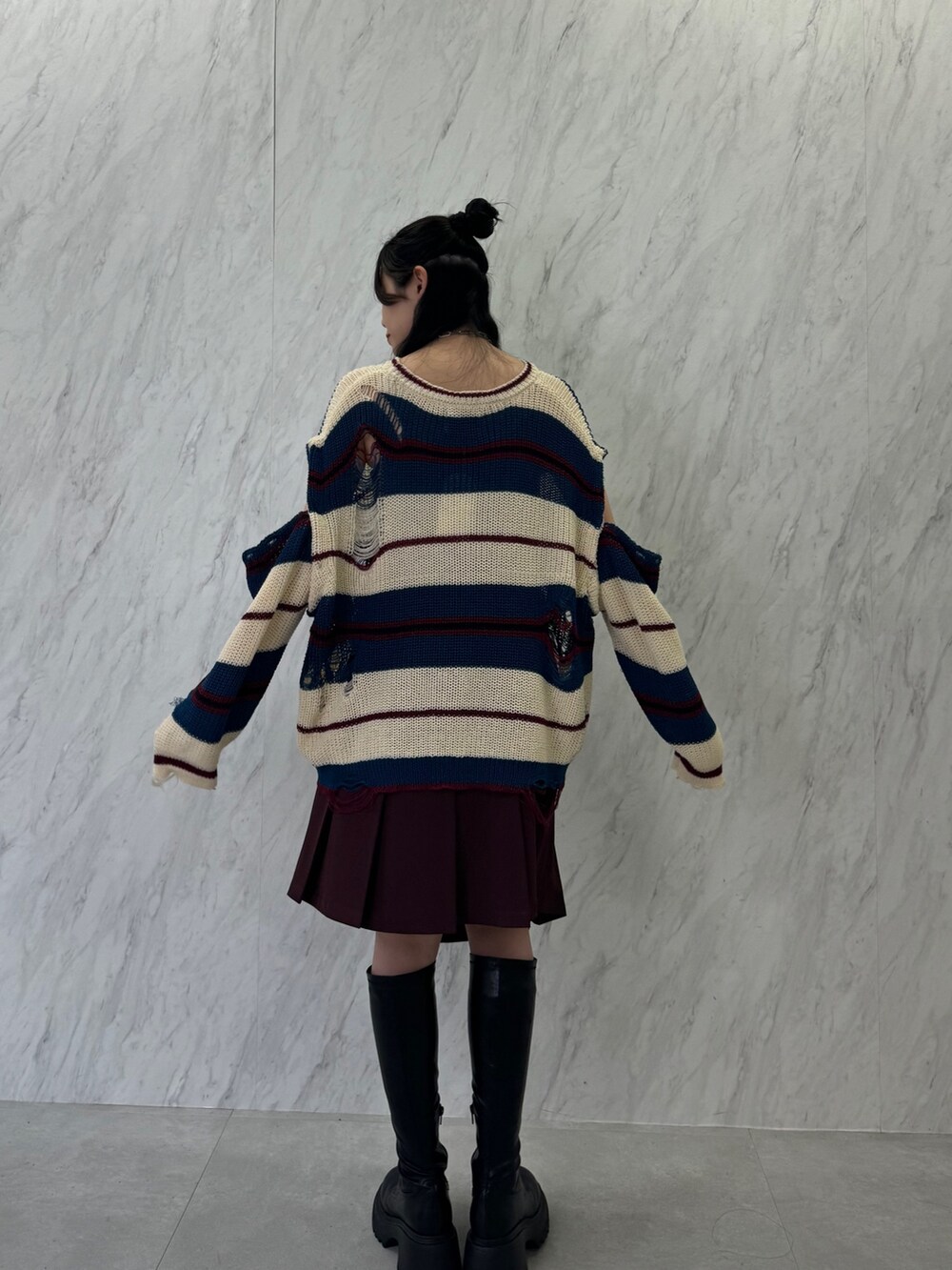 ホワイト系のニット/セーター、レッド系のスカート、ブラック系のブーツを着用したレディースの春コーディネートの4枚目の写真