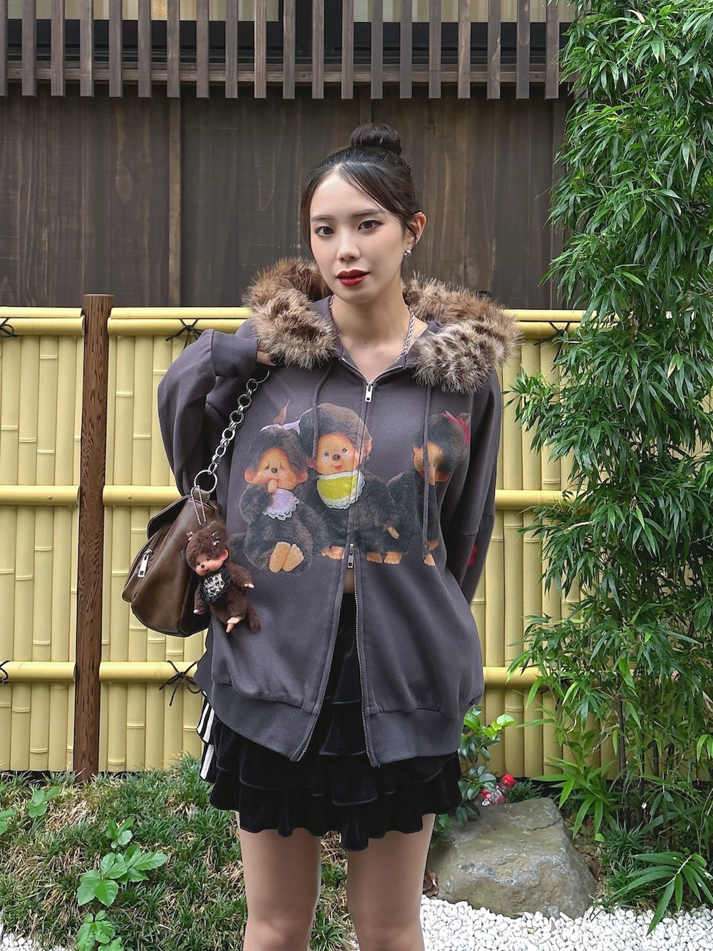 ブラック系のパーカー、ブラック系のスカート、ブラウン系のキーホルダーを着用したレディースの秋コーディネートの3枚目の写真