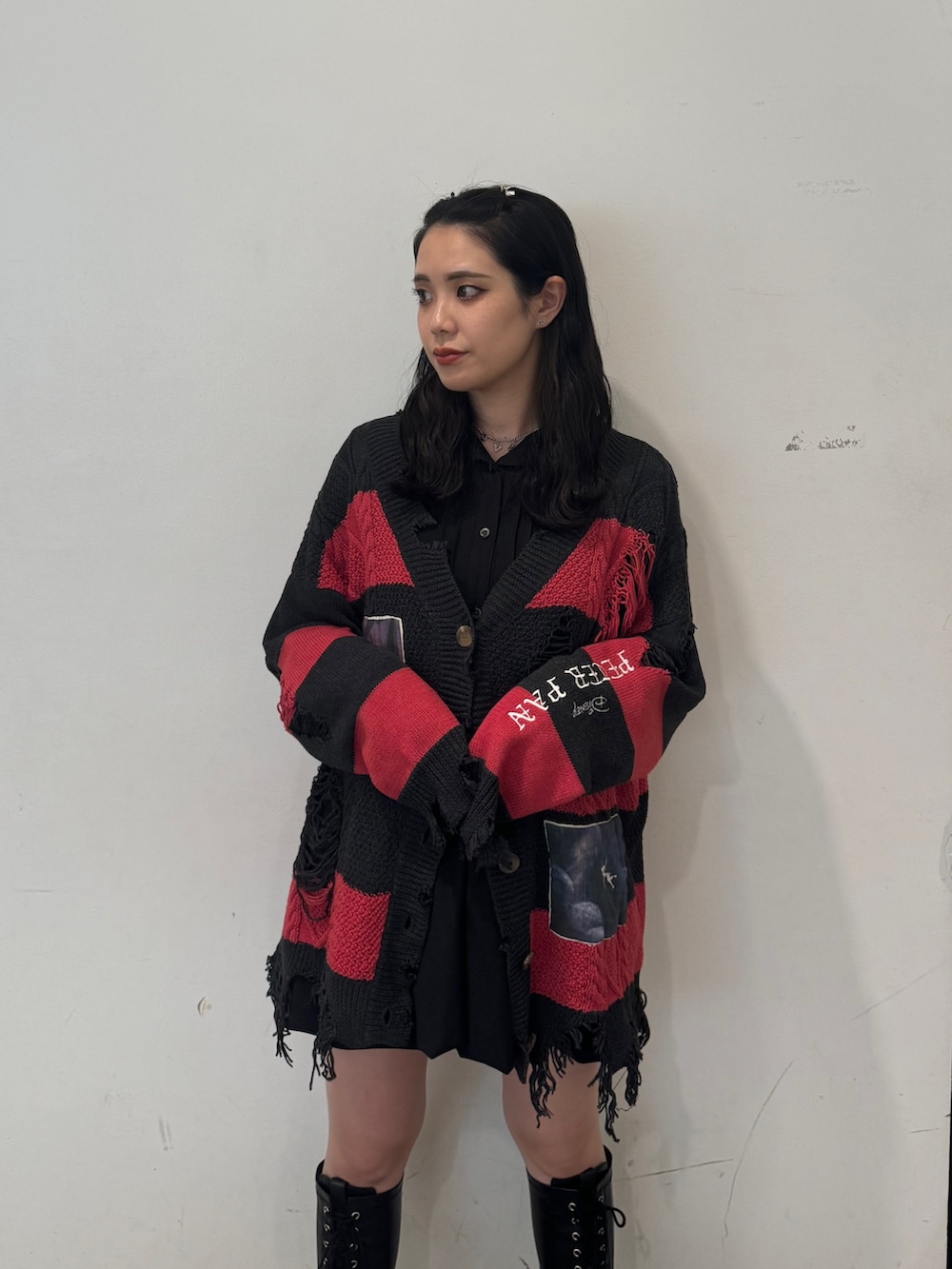 レッド系のカーディガン/ボレロ、ブラック系のワンピース、ブラック系のブーツを着用したレディースの夏コーディネートの5枚目の写真