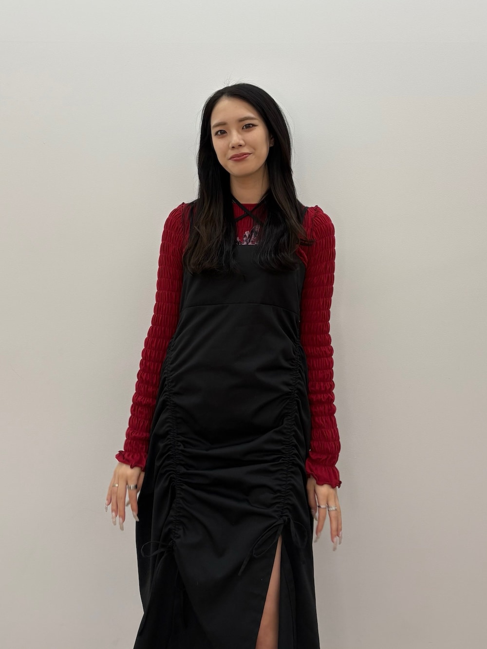 ブラック系のワンピース、レッド系のTシャツ/カットソー、ブラック系のブーツを着用したレディースの春コーディネートの3枚目の写真