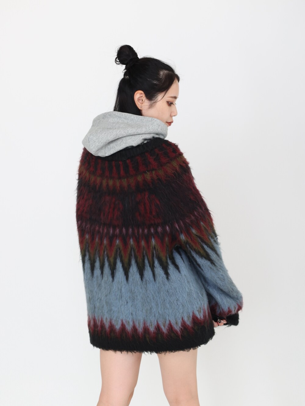 ブラック系のカーディガン/ボレロ、グレー系のパーカー、ブラック系のスカートを着用したレディースの秋コーディネートの4枚目の写真