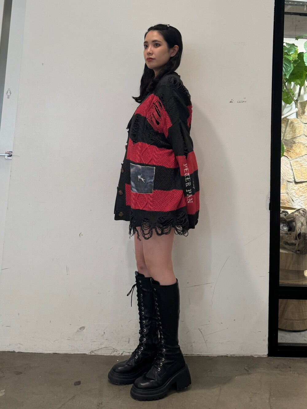 レッド系のカーディガン/ボレロ、ブラック系のワンピース、ブラック系のブーツを着用したレディースの夏コーディネートの3枚目の写真