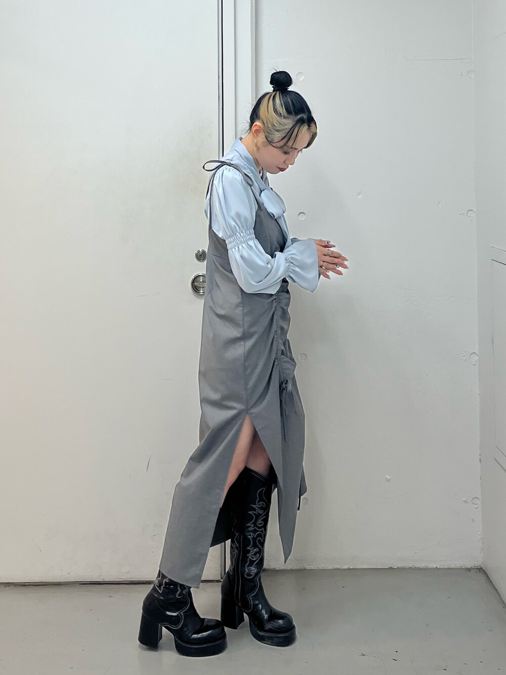 グレー系のワンピース、ブルー系のシャツ/ブラウス、ブラック系のブーツを着用したレディースの冬コーディネートの2枚目の写真