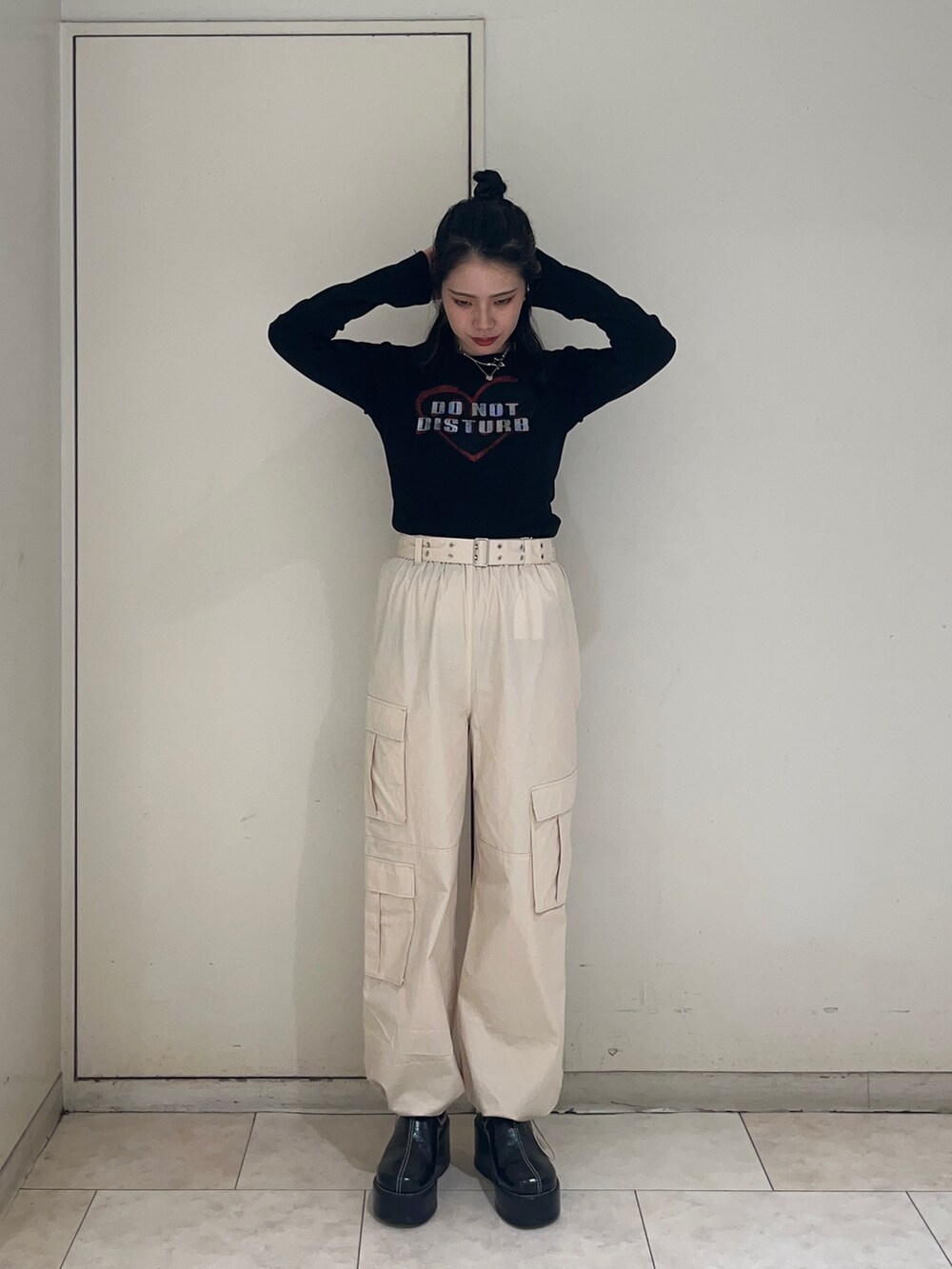 ブラック系のダウンベスト、ホワイト系のカーゴパンツ、ブラック系のTシャツ/カットソーを着用したレディースの秋コーディネートの3枚目の写真